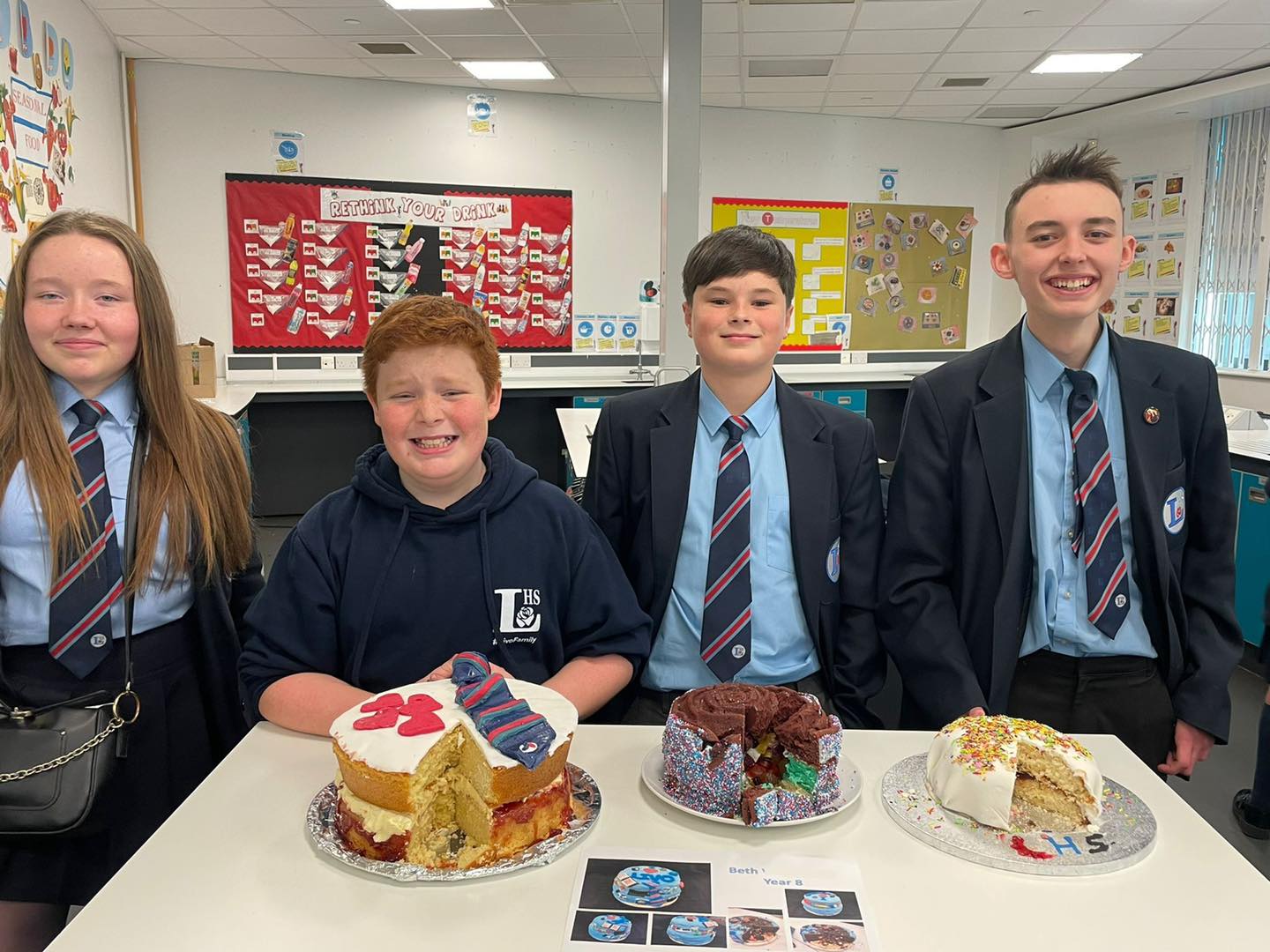 students stand with their bake off cake entries