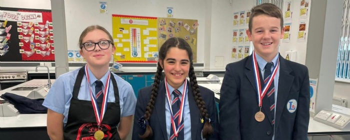 winning students stand together wearing medals